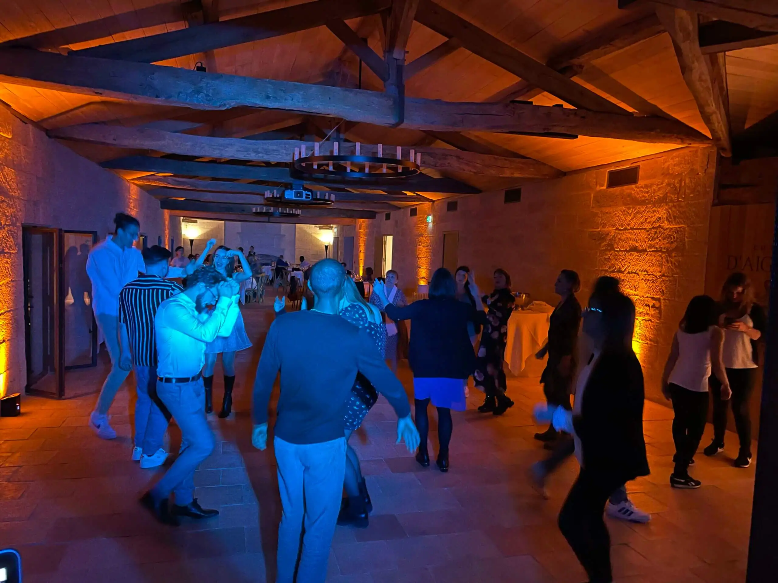 Piste de danse baignée de bleu sous une charpente en bois